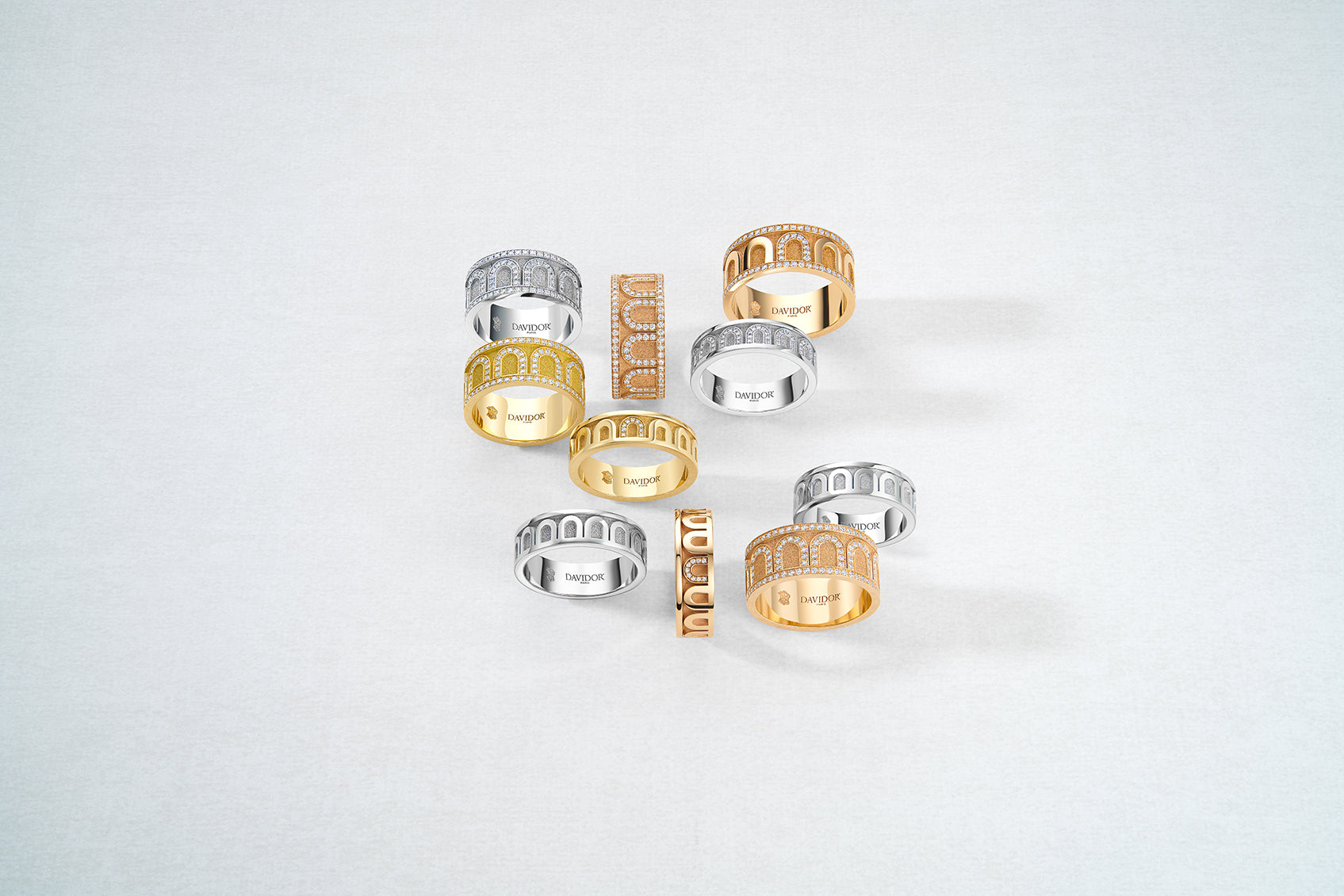 A collection of Bulgari rings displayed on a light gray background. The rings are in various designs and colors, including silver and gold tones, some with intricate patterns and others adorned with sparkling stones.