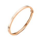 Introducing the L’Arc de DAVIDOR Bangle Mini, an exquisite 18k rose gold bracelet accented with lacquered ceramic. Inspired by the iconic DAVIDOR Arch motif, this stackable bangle features a repeating oval design along its edge and is secured with a discreet hinge clasp. Elegantly presented against a white background, it exemplifies timeless sophistication.