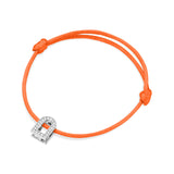 Introducing the L'Arc Voyage Charm PM: an orange silk cord bracelet highlighted by a stunning lock-shaped charm in 18k white gold, embellished with Galerie diamonds. The bracelet is elegantly tied with a simple knot on each side of the charm, evoking the essence of Paris Atelier craftsmanship.