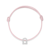 The L'Arc Voyage Charm PM bracelet from the Paris Atelier collection elegantly showcases an 18k white gold, arch-shaped charm embellished with Galerie diamonds. It is beautifully set on a delicate pink silk cord, featuring an adjustable design for a secure fit.