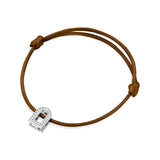 The L'Arc Voyage Charm PM bracelet by Paris Atelier features an 18k white gold lock-shaped charm adorned with Galerie Diamonds, set on a brown silk cord with adjustable knots.