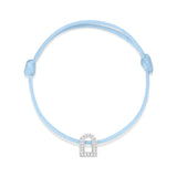 The L'Arc Voyage Charm PM bracelet, crafted by Paris Atelier, features an elegant arch-shaped charm in 18k white gold embellished with Galerie diamonds. This light blue silk cord piece is adjustable and finished with simple knots on each end.