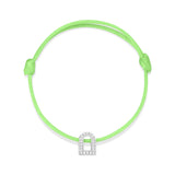 The L'Arc Voyage Charm PM bracelet from Paris Atelier features a neon green silk cord with an adjustable knot design and a silver charm shaped like a curved arch. This elegant piece, crafted in 18k white gold and embedded with Galerie diamonds, is beautifully displayed against a plain white background.